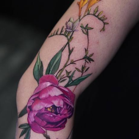 Farbiges Pfingstrosen-Tattoo am Arm