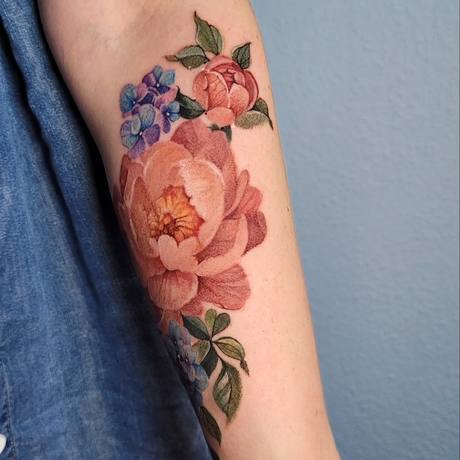 Farbiges Blüten-Tattoo am Unterarm