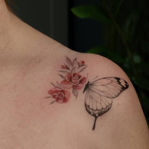 Feiner Schmetterling mit Rose an der Schulter